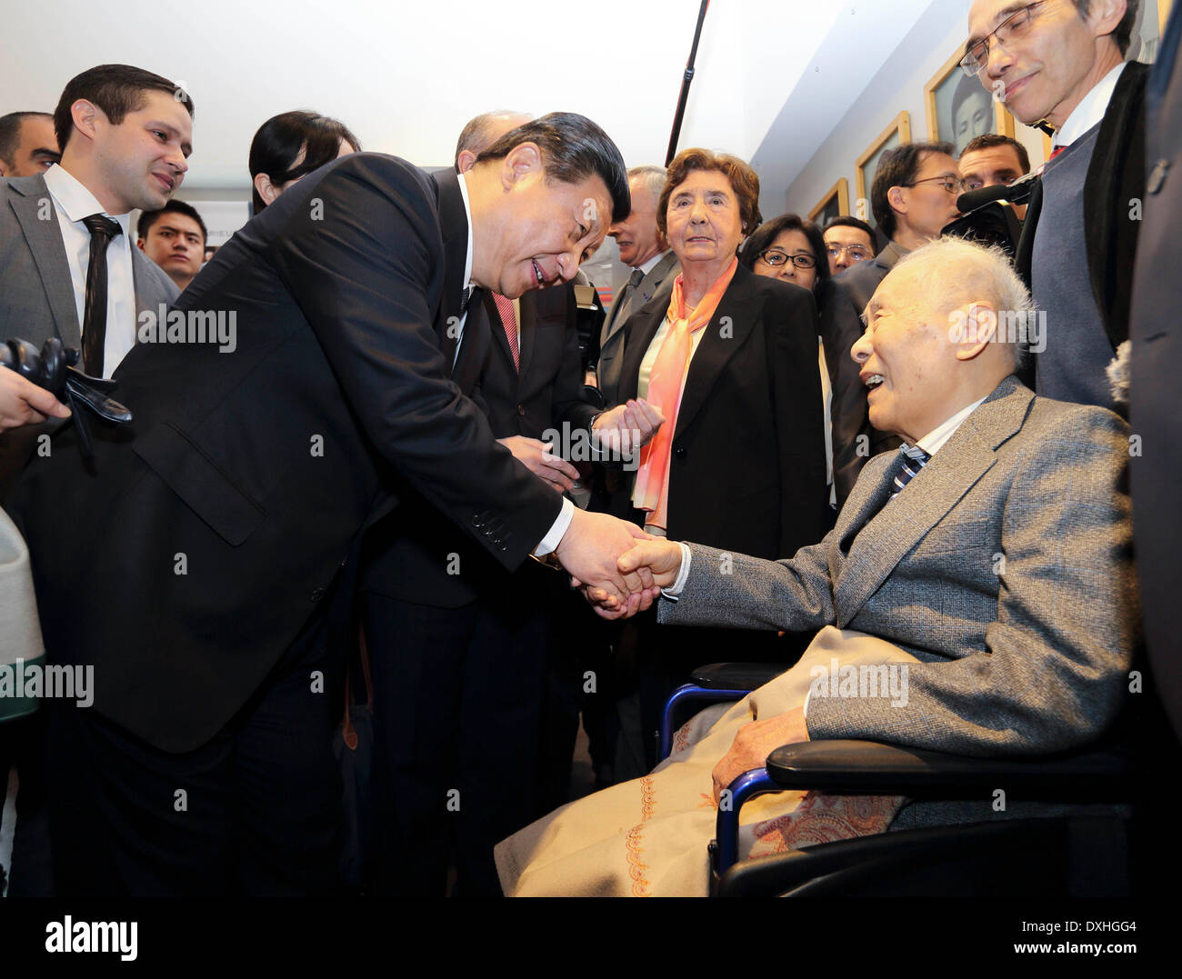 Lyon, France. 26th Mar, 2014. Chinese President Xi Jinping (L, front) shakes hands with 99-year-old Chinese-French translator Li Zhihua while Xi visited the former site of the Lyon Sino-French Institute in Lyon, France, March 26, 2014. Li Zhihua was once a student of the Lyon Sino-French Institute. He spent 27 years translating the Chinese classic novel 'A Dream in Red Mansions' into French and became the first Chinese who ever introduced the novel to France. Credit:  Lan Hongguang/Xinhua/Alamy Live News Stock Photo