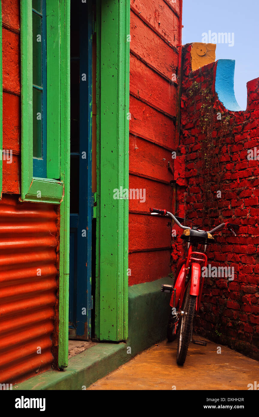 A red bicycle resting against a red wall in Buenos Aires, Argentina. Stock Photo