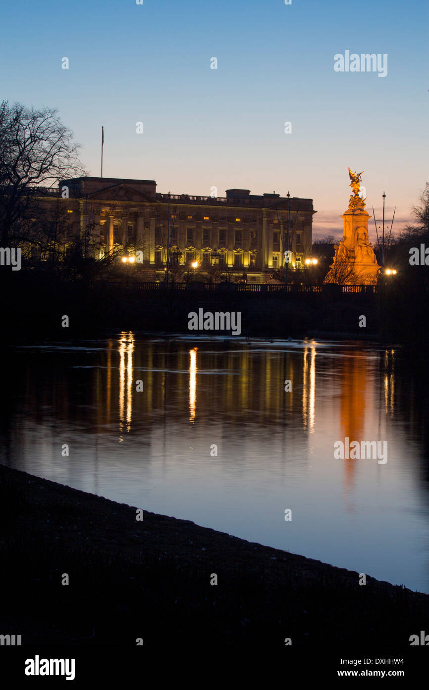 Buckingham Palace and Victoria Memorial reflected in lake in St James's Park at night twilight dusk London England UK Stock Photo