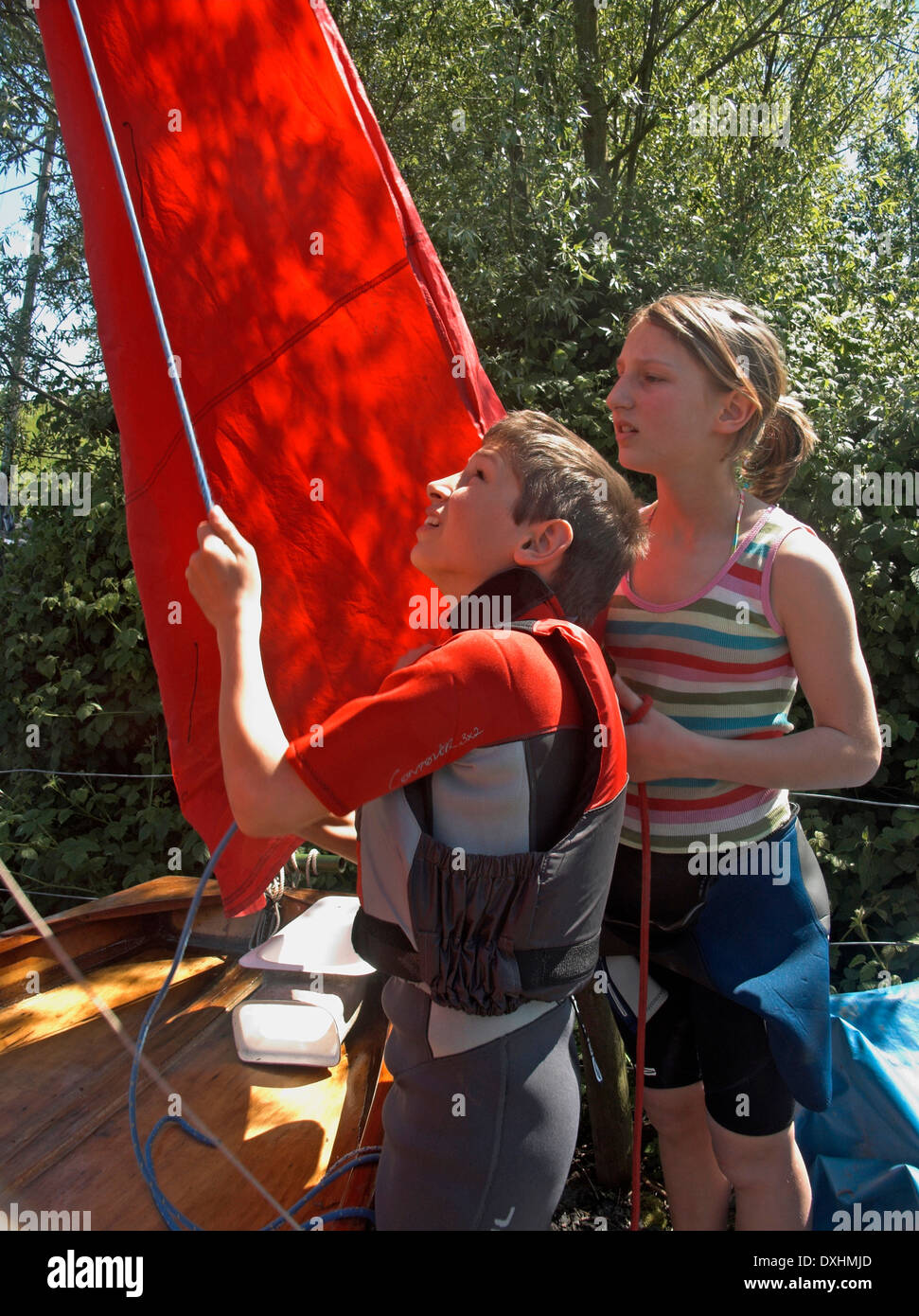 Model released twin brother and sister rigging the sails and mast on a