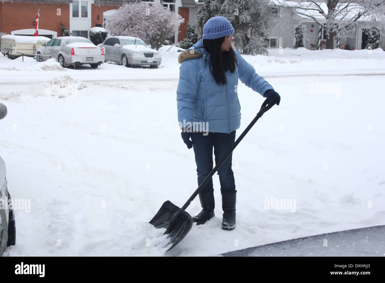 Lady shoveling snow off sidewalk after a snowfall Stock Photo Alamy