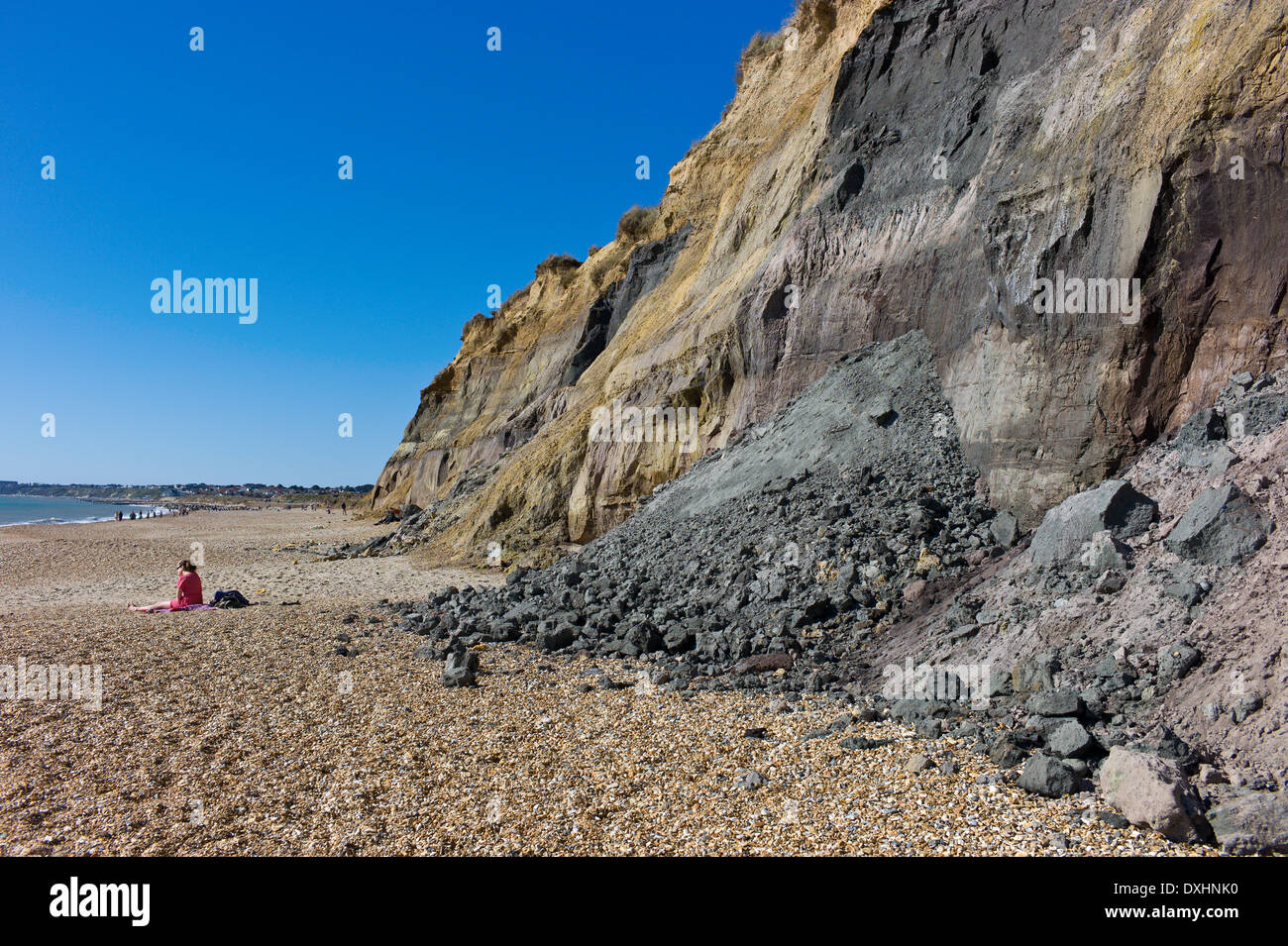 Sunbather sitting on the beach dangerously close to recent rock fall