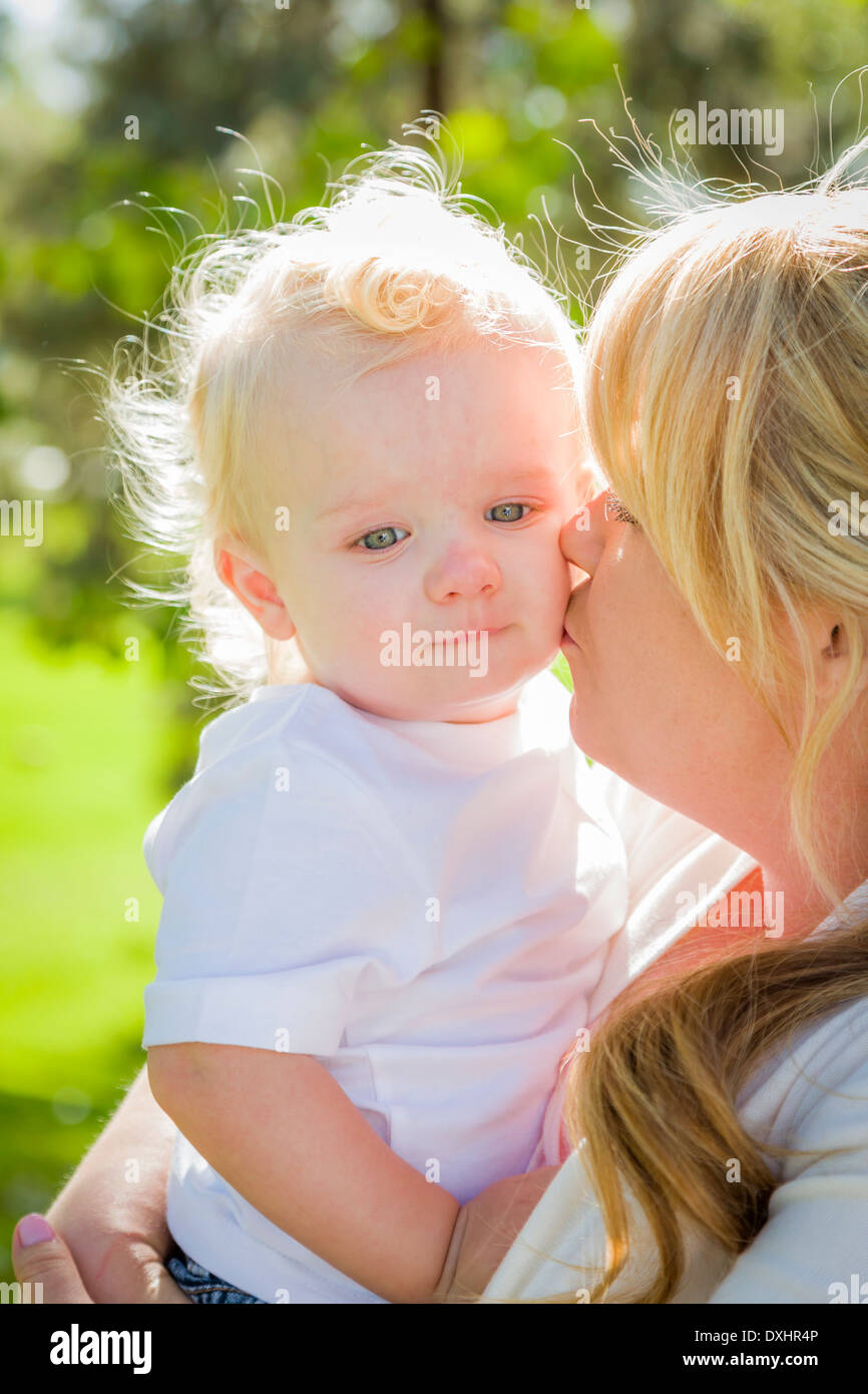 Young Mother Holding Her Adorable Baby Boy in the Park. Stock Photo