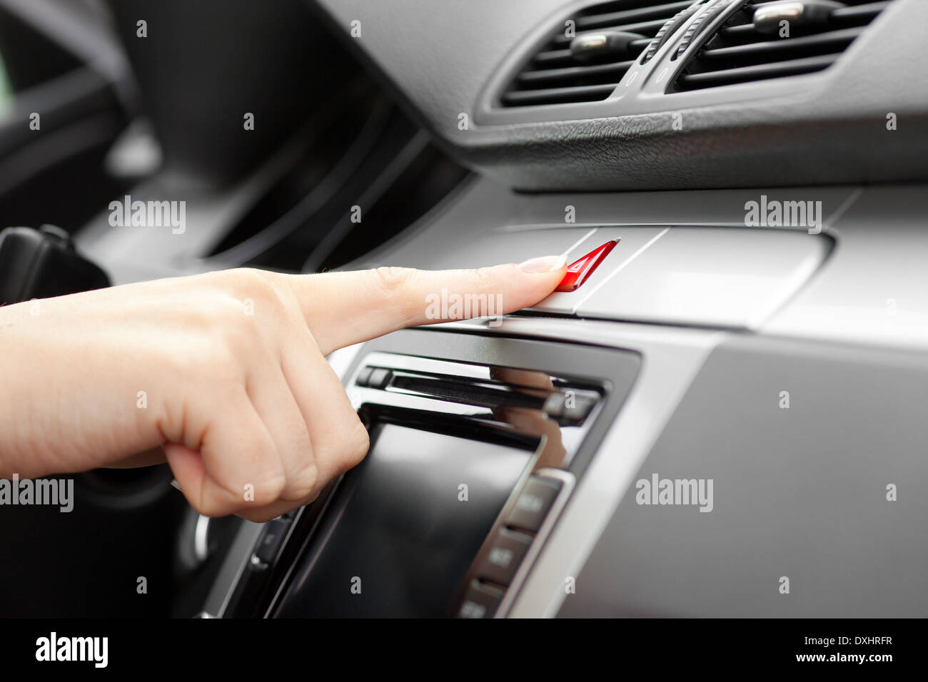 hand pressing Car emergency lights button on dashboard Stock Photo