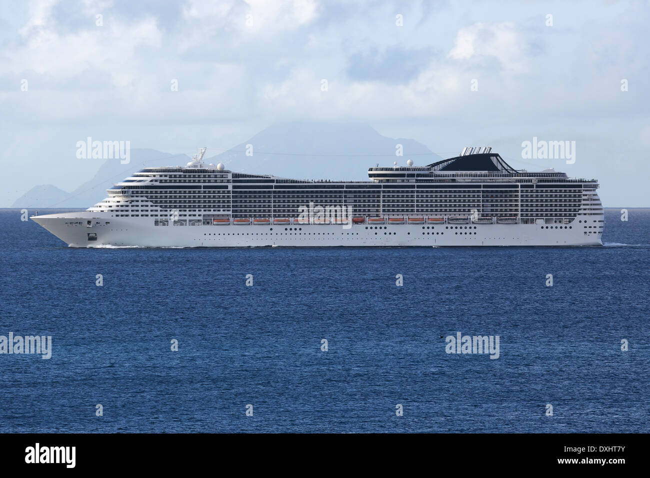 A cruise ship is sailing in the sea in front of a tropical island Stock Photo