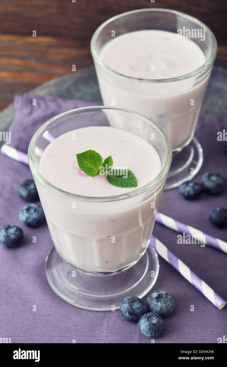 Yogurt with ripe fresh blueberry in glass on wooden background Stock Photo