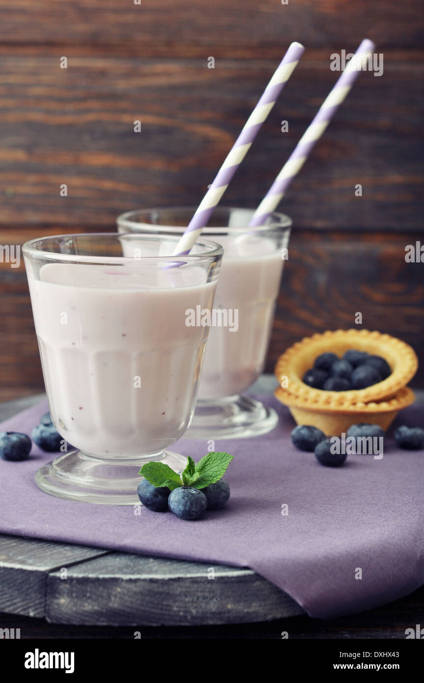 Yogurt with ripe fresh blueberry in glass on wooden background Stock Photo
