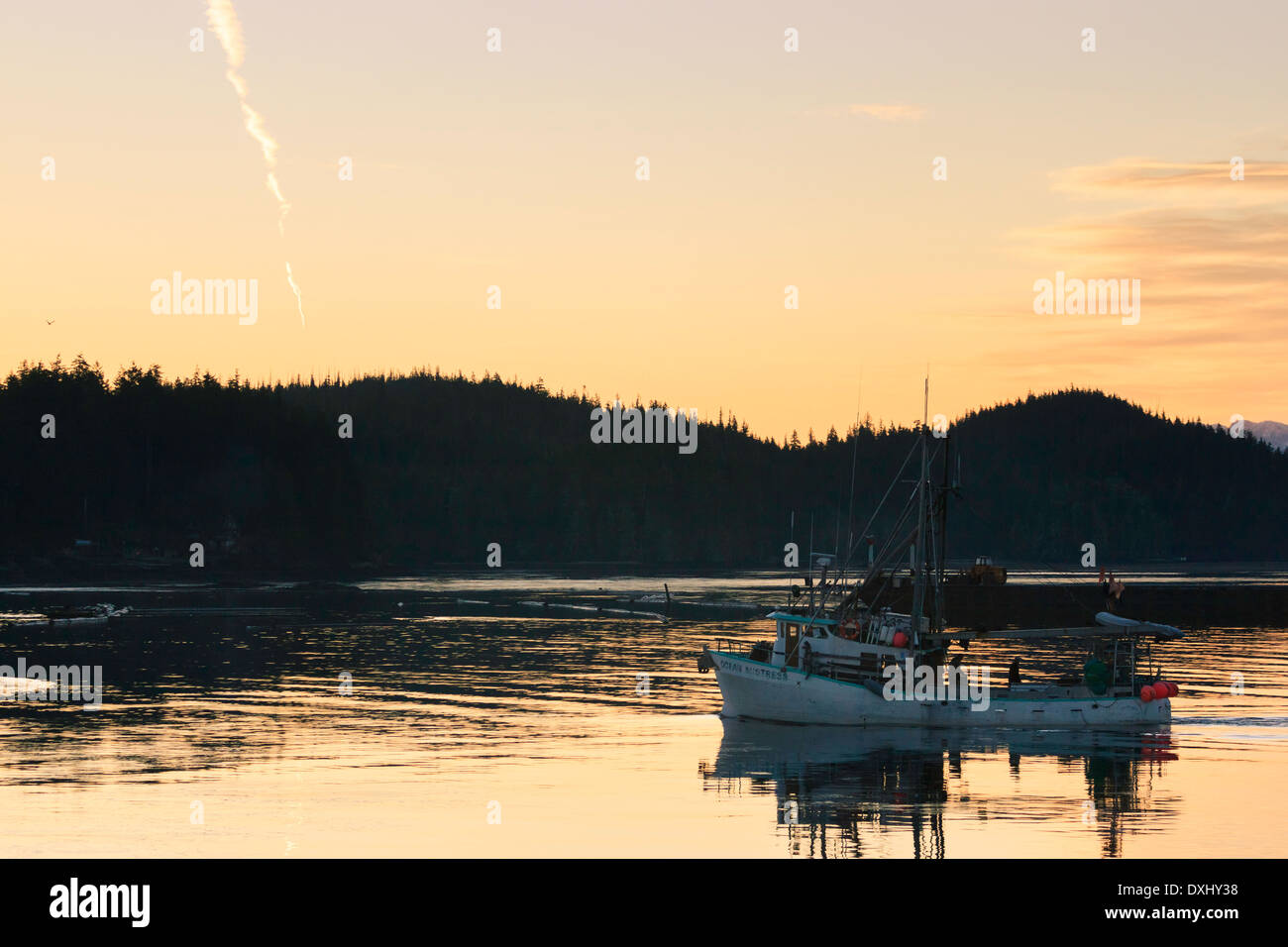 A fishing boat departs at sunrise in the calm waters of Hardy Bay, British Columbia. Stock Photo