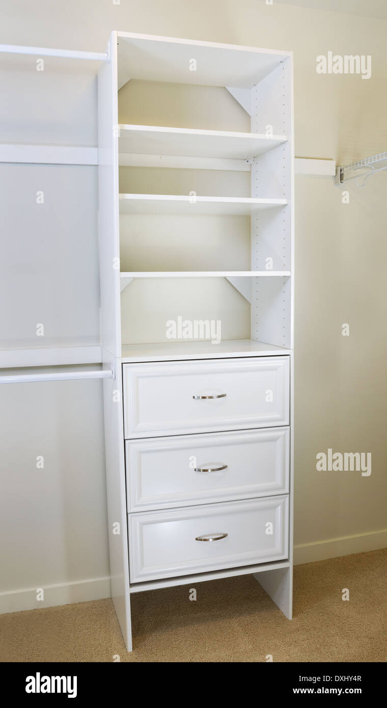 Vertical photo of modern white shelf inside of master bedroom closet