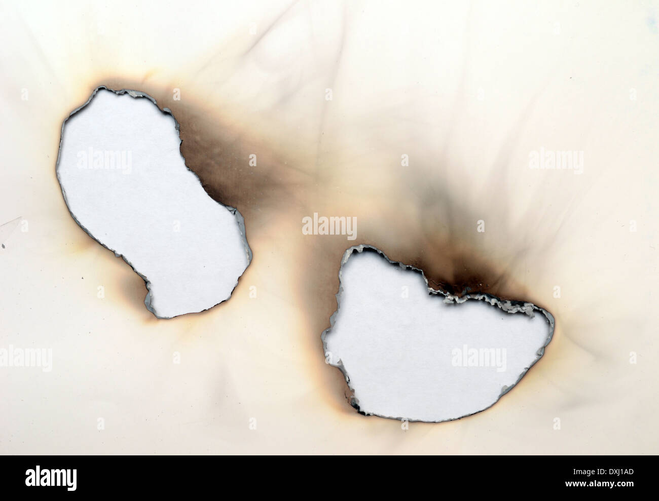 burnt holes in a paper Stock Photo Alamy