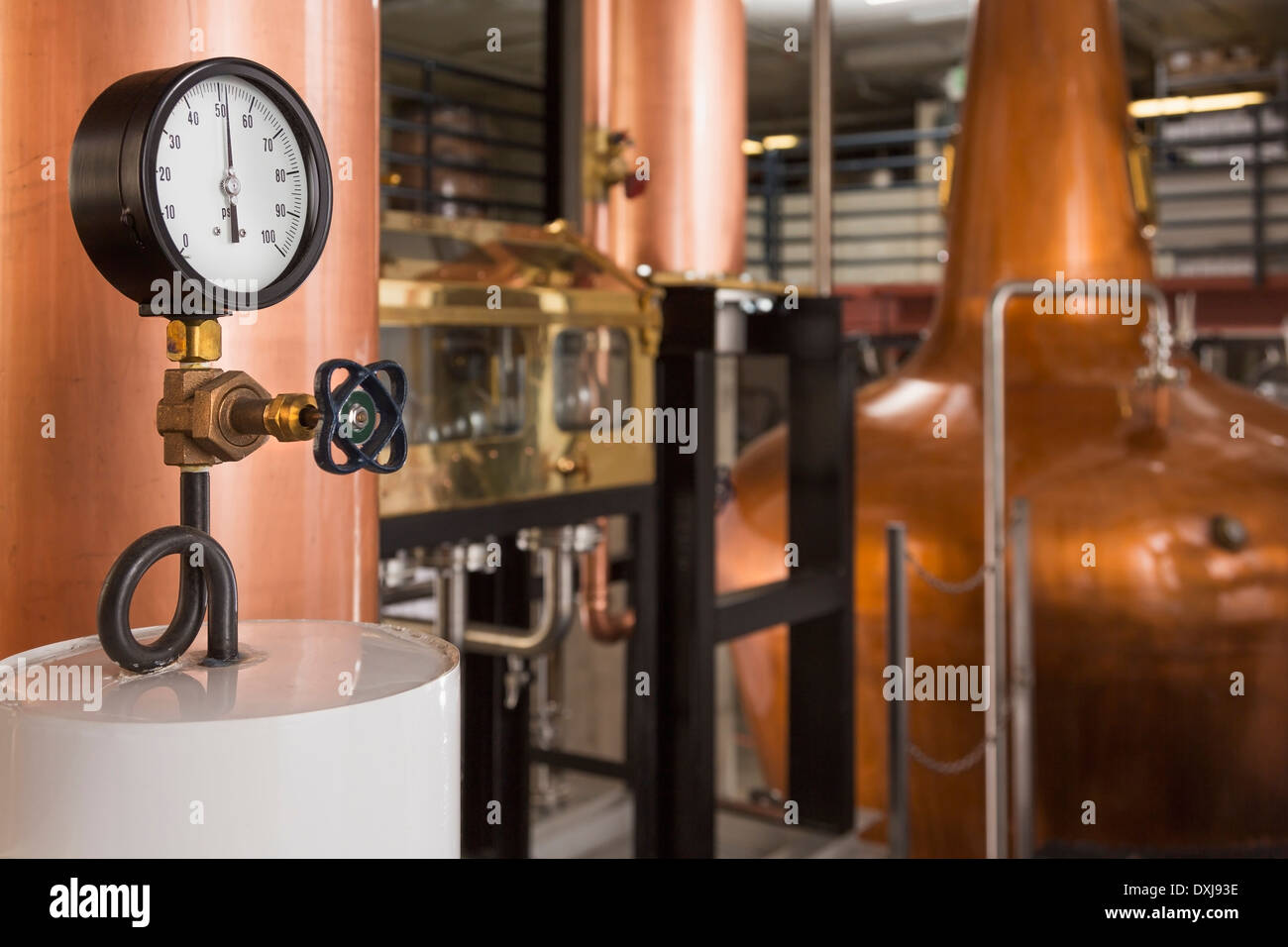 Gauge and copper stills in distillery Stock Photo