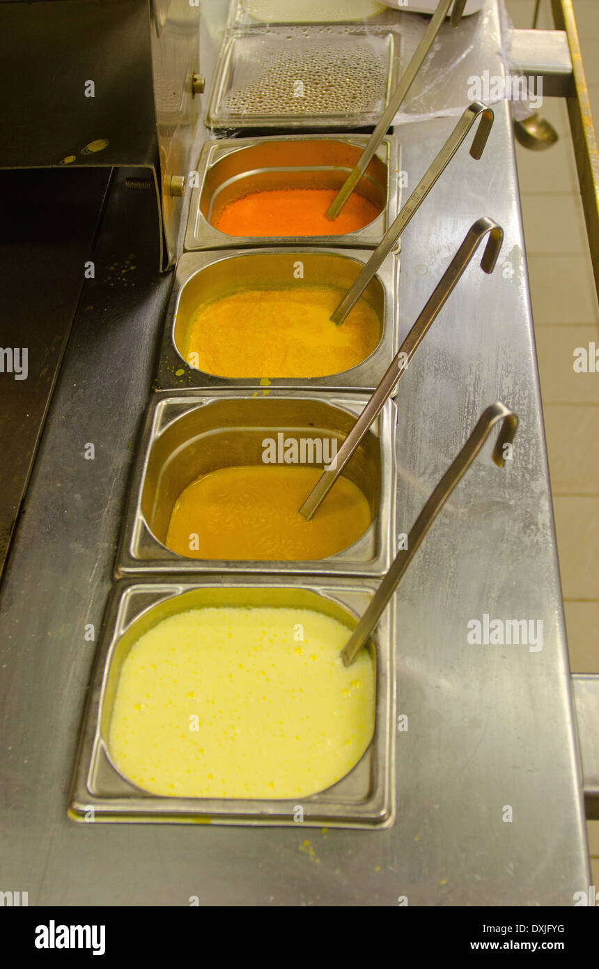 Colored sauces with ladles in restaurant kitchen Stock Photo
