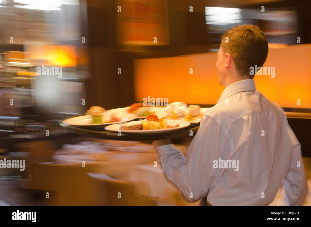 Waiter carrying tray with dishes through resturant Stock Photo Alamy