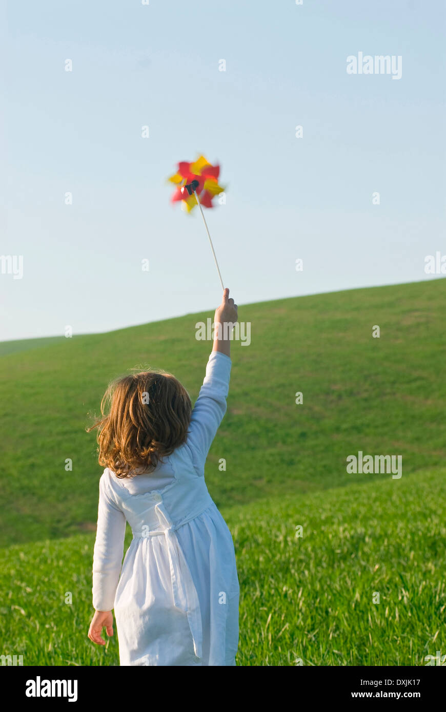 Girl holding up pinwheel in field Stock Photo - Alamy