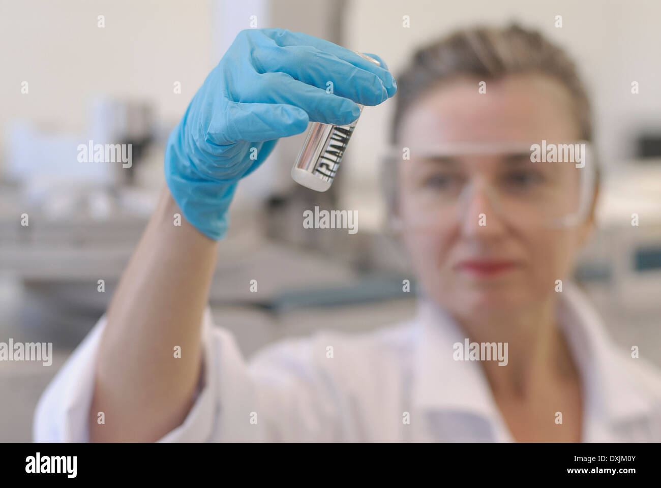 Lab technician looking at sample bottle in laboratory focus on hand Stock Photo