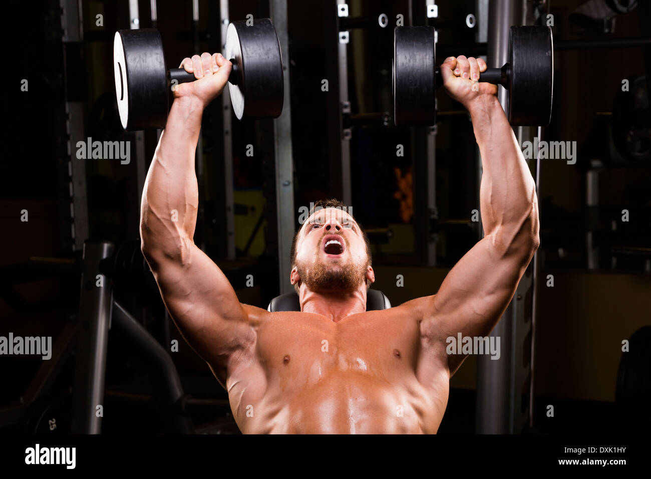 Caucasian man doing incline chest presses with dumbbells in gym Stock Photo