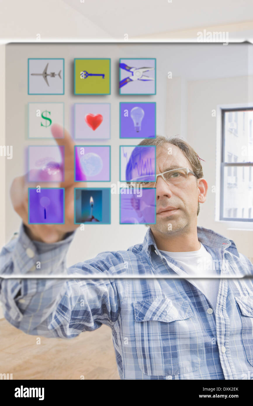 Hispanic man using mobile apps on virtual screen Stock Photo