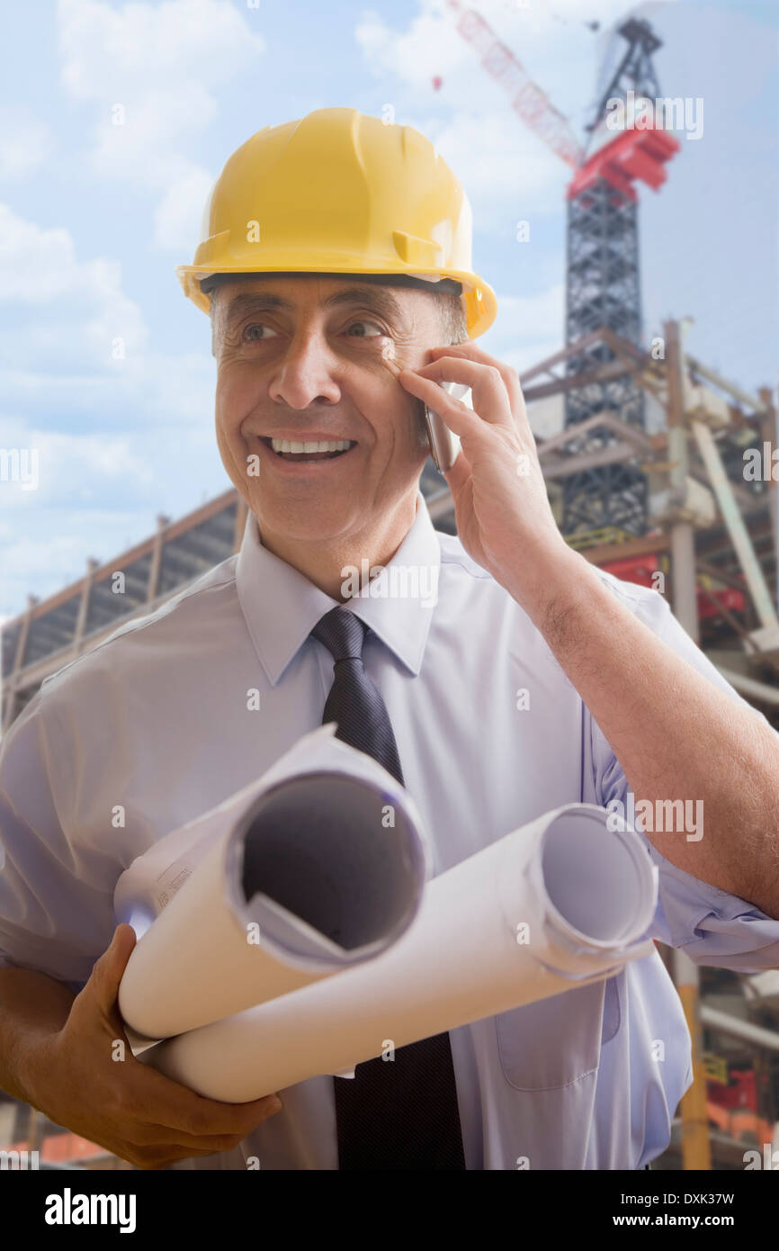 Hispanic architect talking on cell phone at construction site Stock Photo