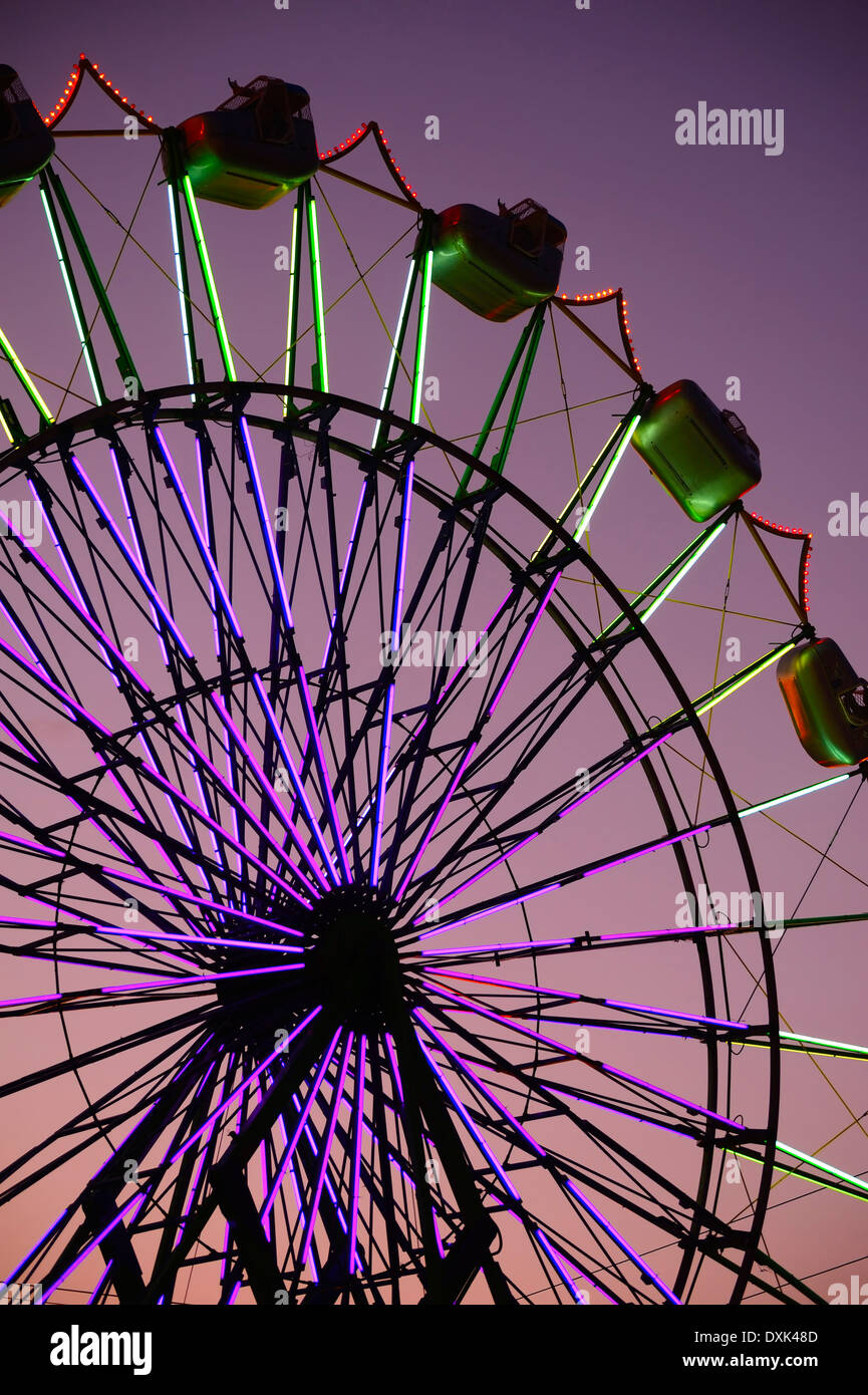 Neon Ferris Wheel ride at amusement park at night Stock Photo - Alamy