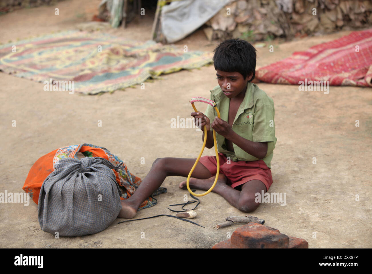 A tribal boy making a Gulel or slingshot. Keredari village and block, District Hazaribaug, Jharkhand, India. Stock Photo