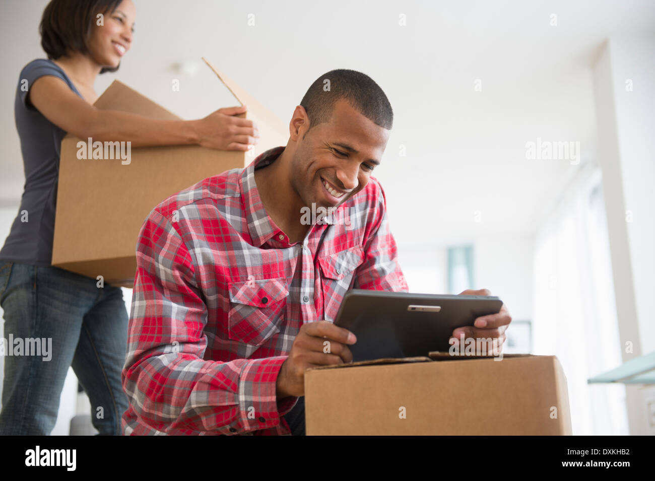 Couple with digital tablet and moving boxes Stock Photo