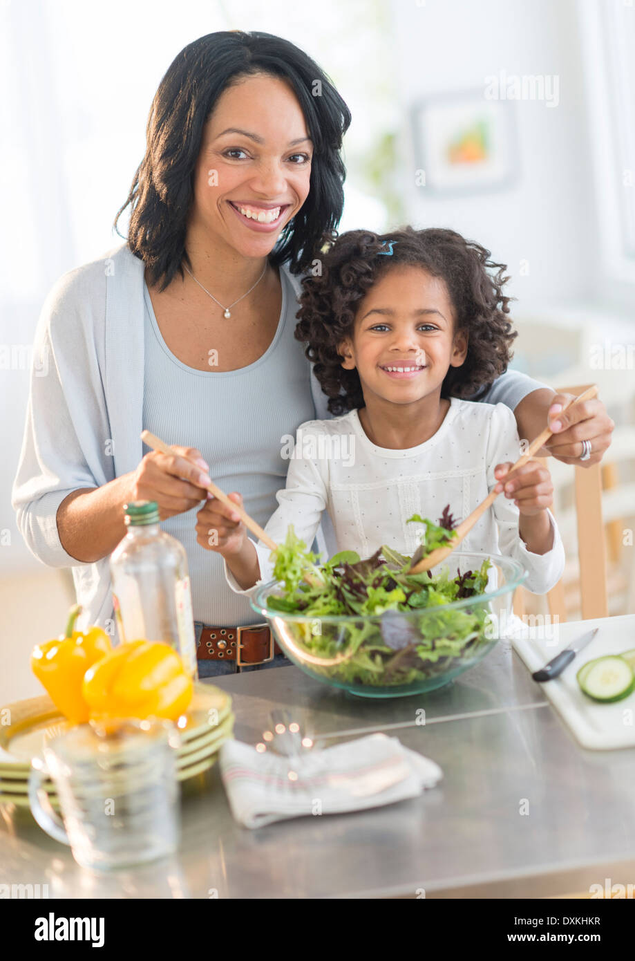 African American mother and daughter tossing salad Stock Photo