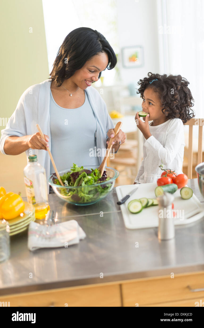 African American mother and daughter tossing salad Stock Photo