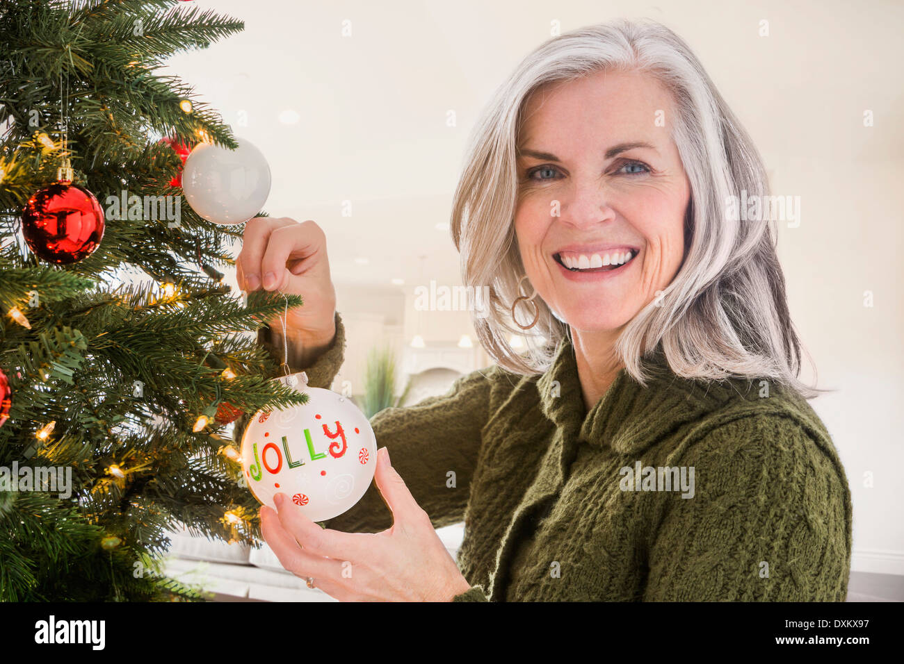 Portrait of Caucasian woman hanging ornaments on Christmas tree Stock Photo