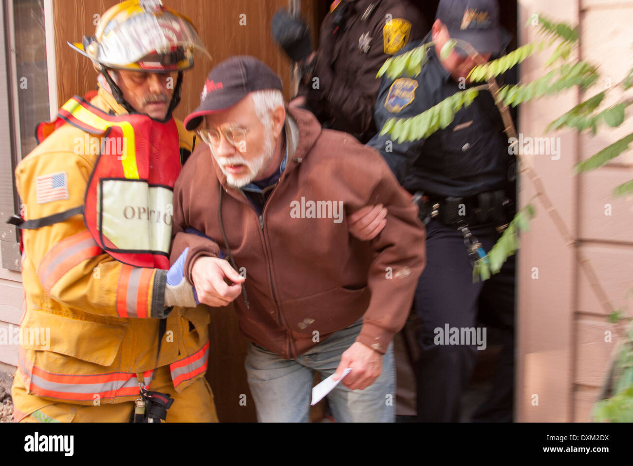 A firefighter helping a patient from an emergency scene with police