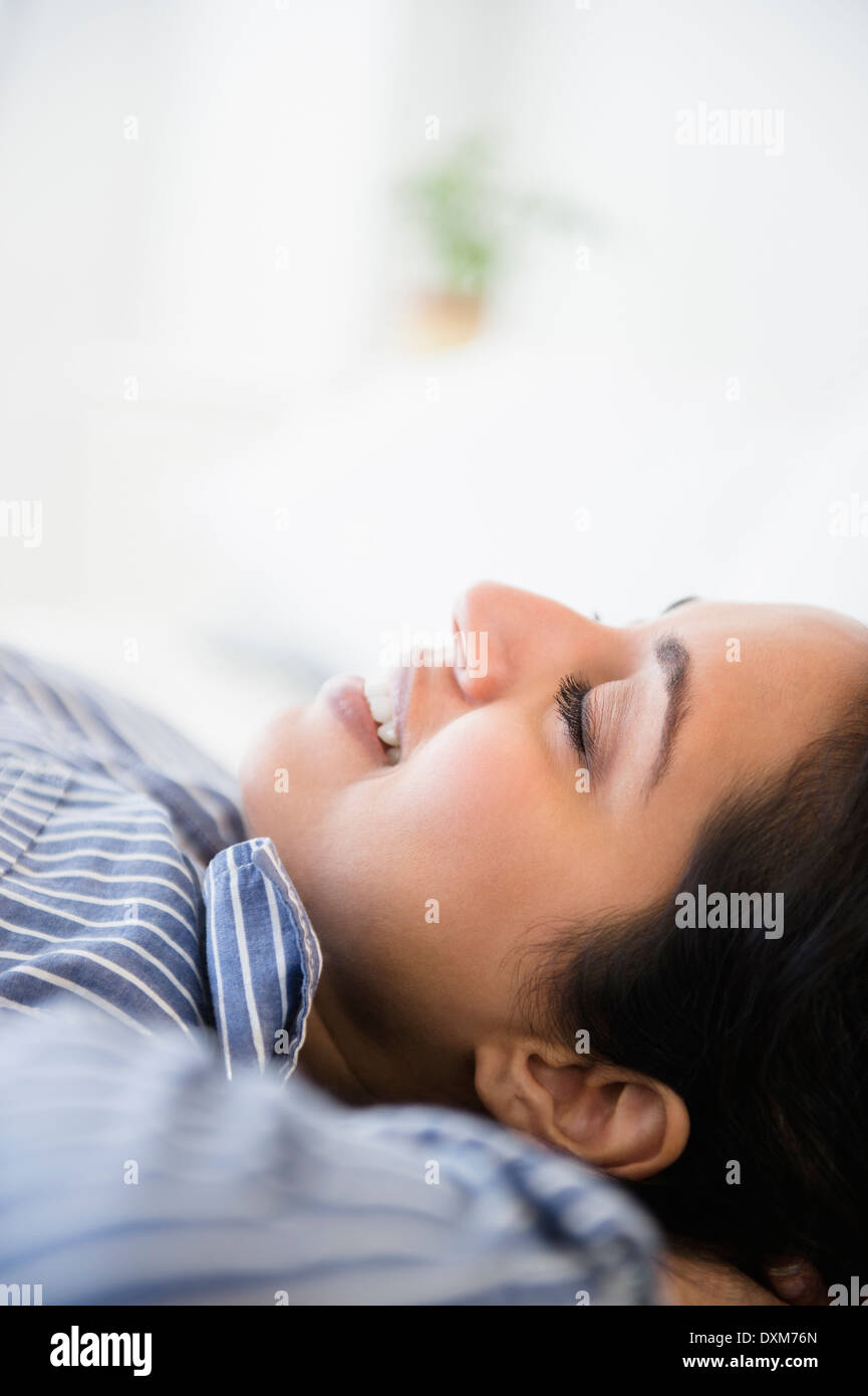 Close up of serene Asian woman laying with hands behind head Stock Photo