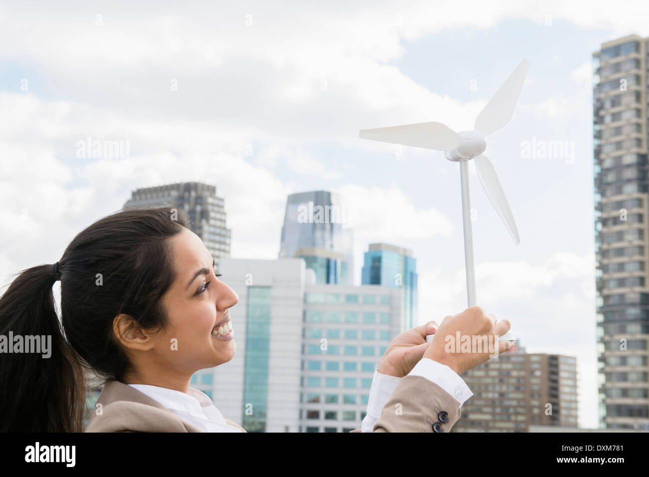 Asian businesswoman holding wind turbine model Stock Photo
