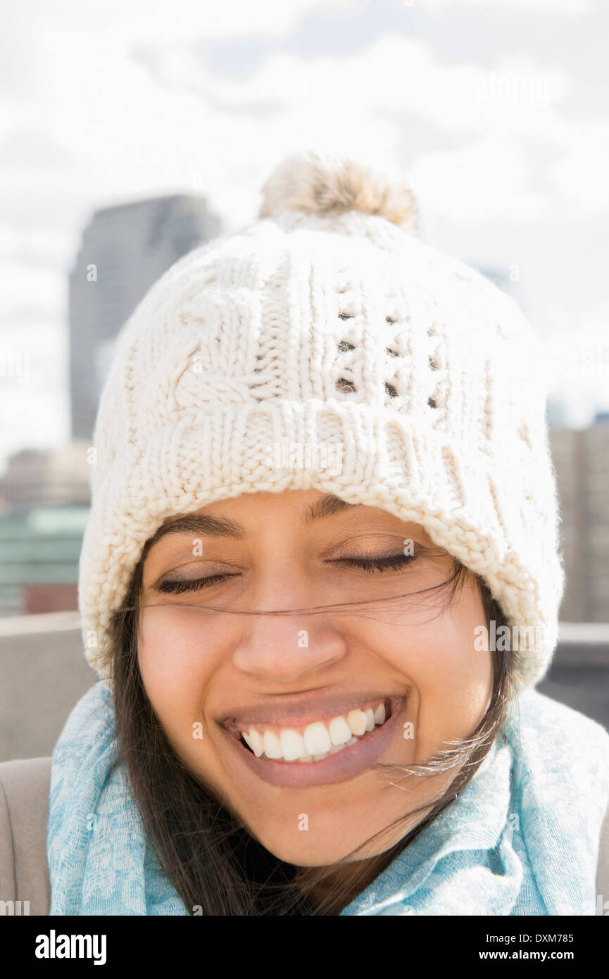 Close up of Asian woman smiling in knit hat with eyes closed Stock Photo