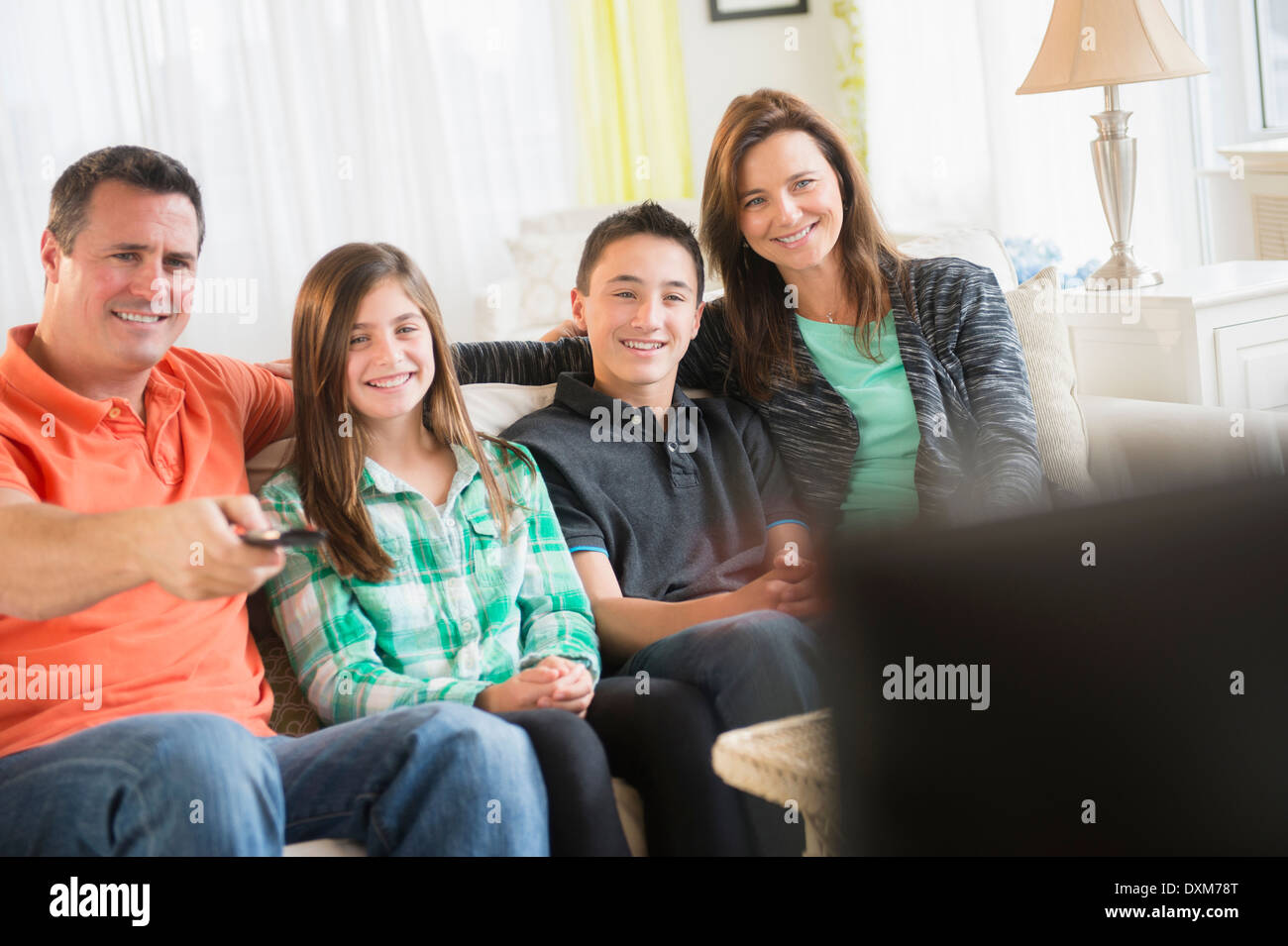 Caucasian family watching TV in living room Stock Photo