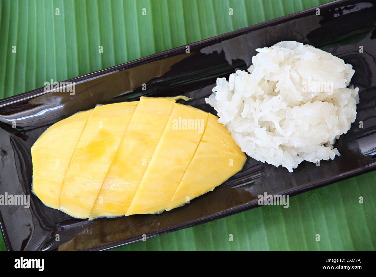 Ripe mango and sticky rice in dish on banana leaves,local Thai foods. Stock Photo