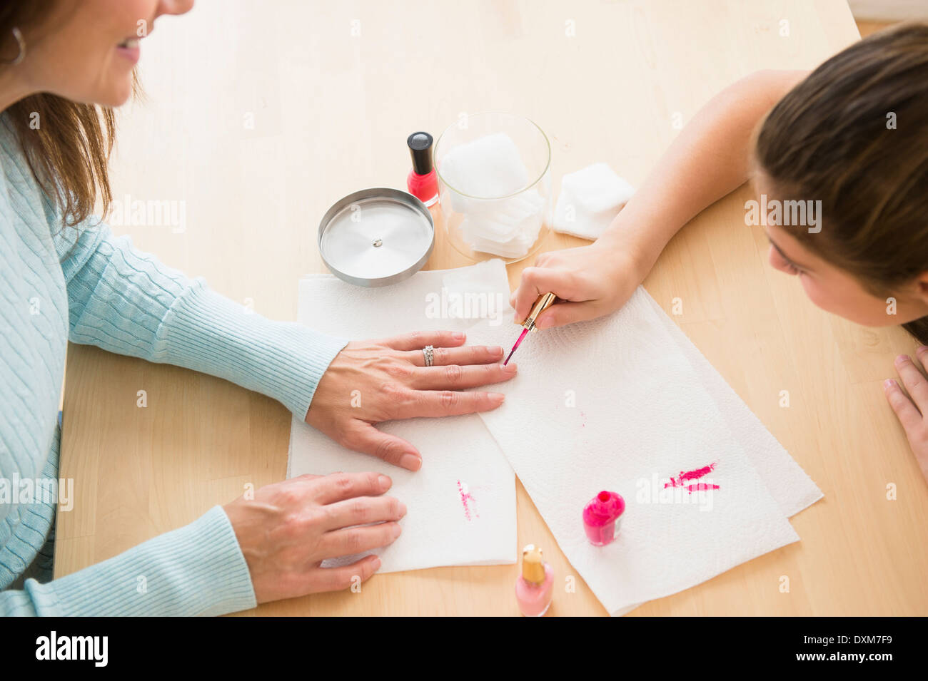 Caucasian girl giving mother a manicure Stock Photo