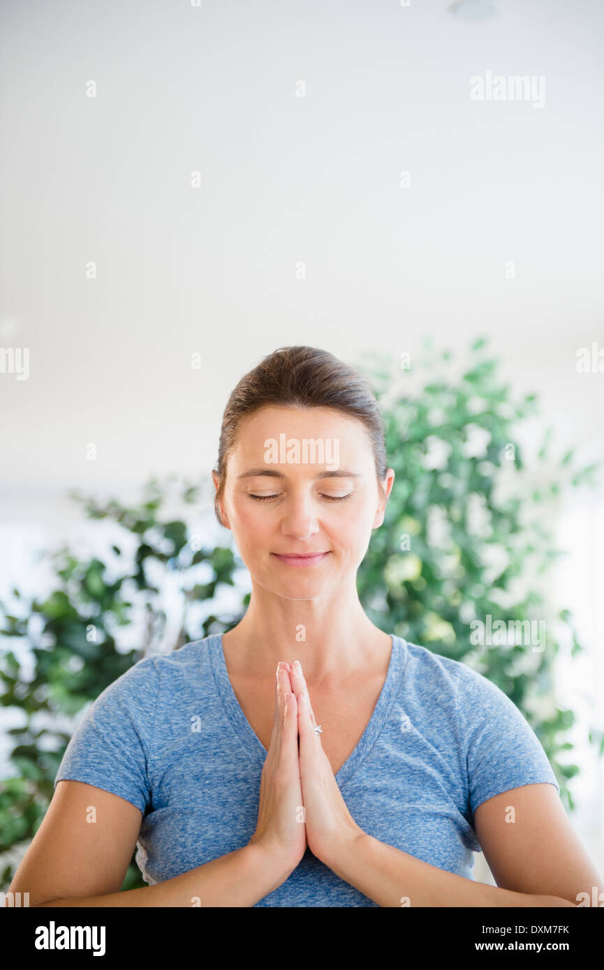 Serene Caucasian woman with hands in prayer position Stock Photo