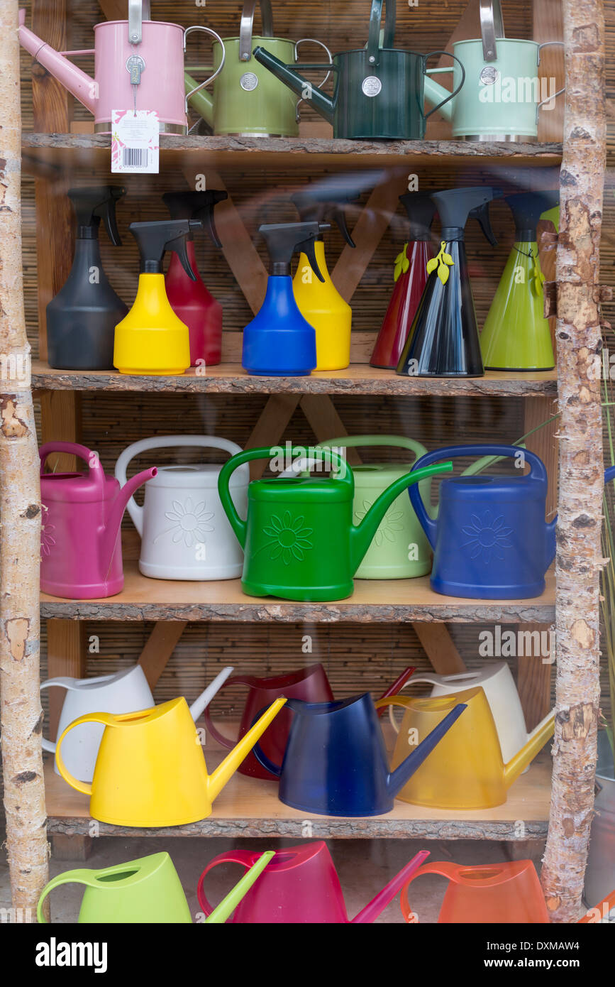 Shelf with coloured watering cans and spray bottles Stock Photo Alamy