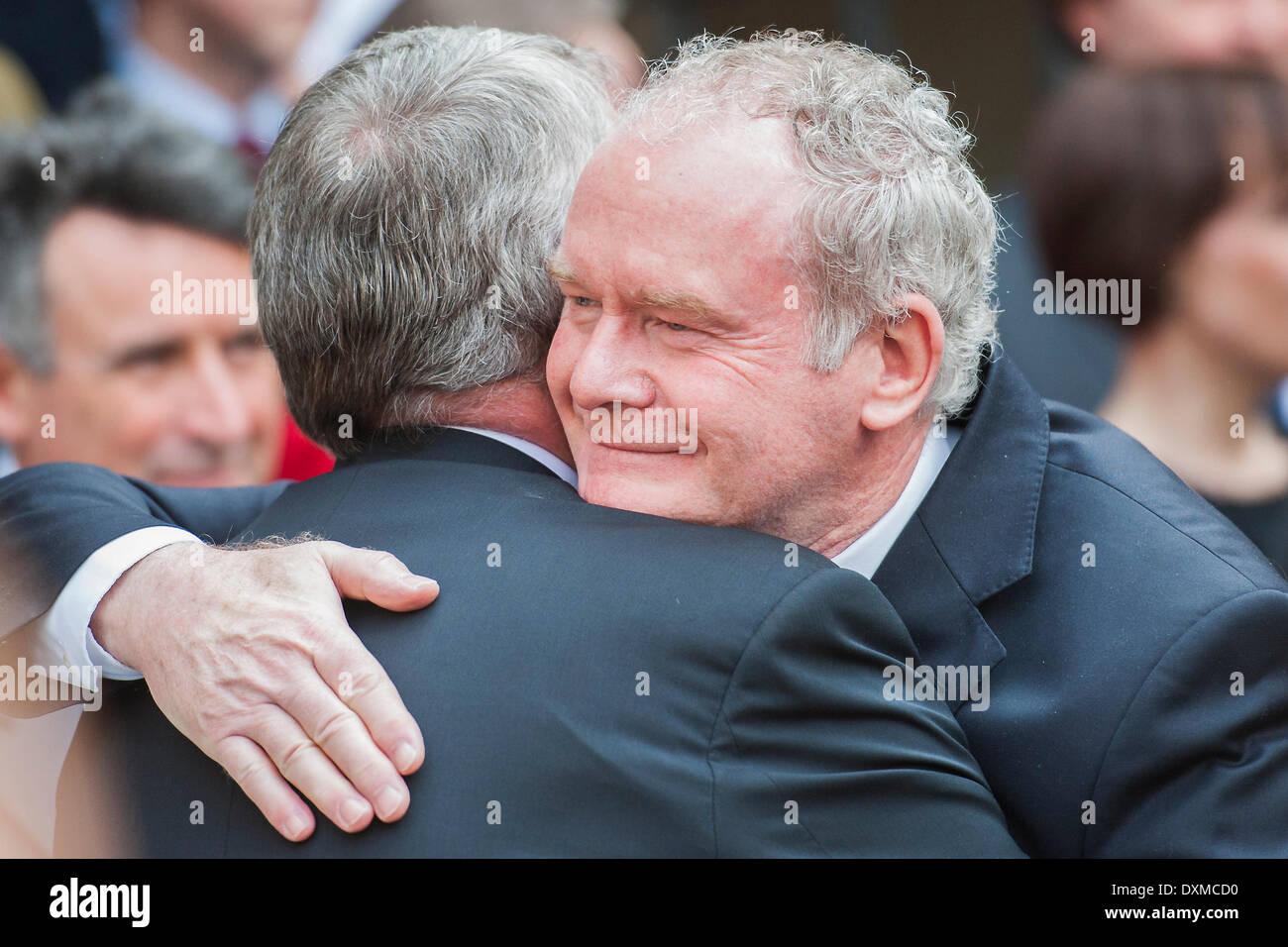 London, UK . 27th Mar, 2014. Martin McGuiness hugs Hilary Benn on his way out. Tony Benn's funeral at 11.00am at St Margaret's Church, Westminster. His body was brought in a hearse from the main gates of New Palace Yard at 10.45am, and was followed by members of his family on foot. The rout was lined by admirers. On arrival at the gates it was carried into the church by members of the family. Thursday 27th March 2014, London, UK. Credit:  Guy Bell/Alamy Live News Stock Photo