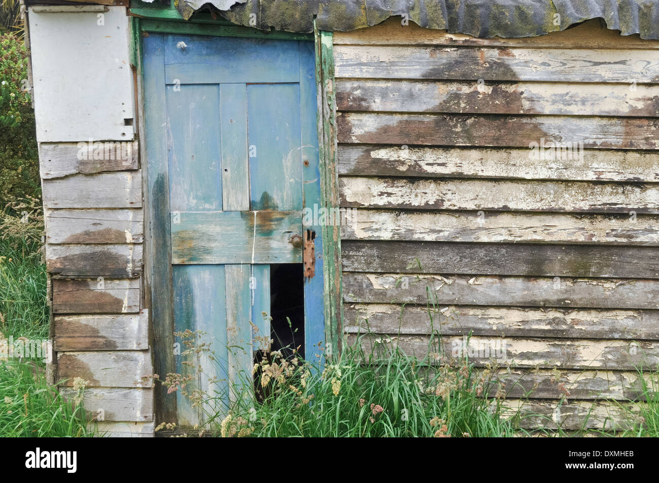 Wooden hut with weathered wooden broken door. Stock Photo