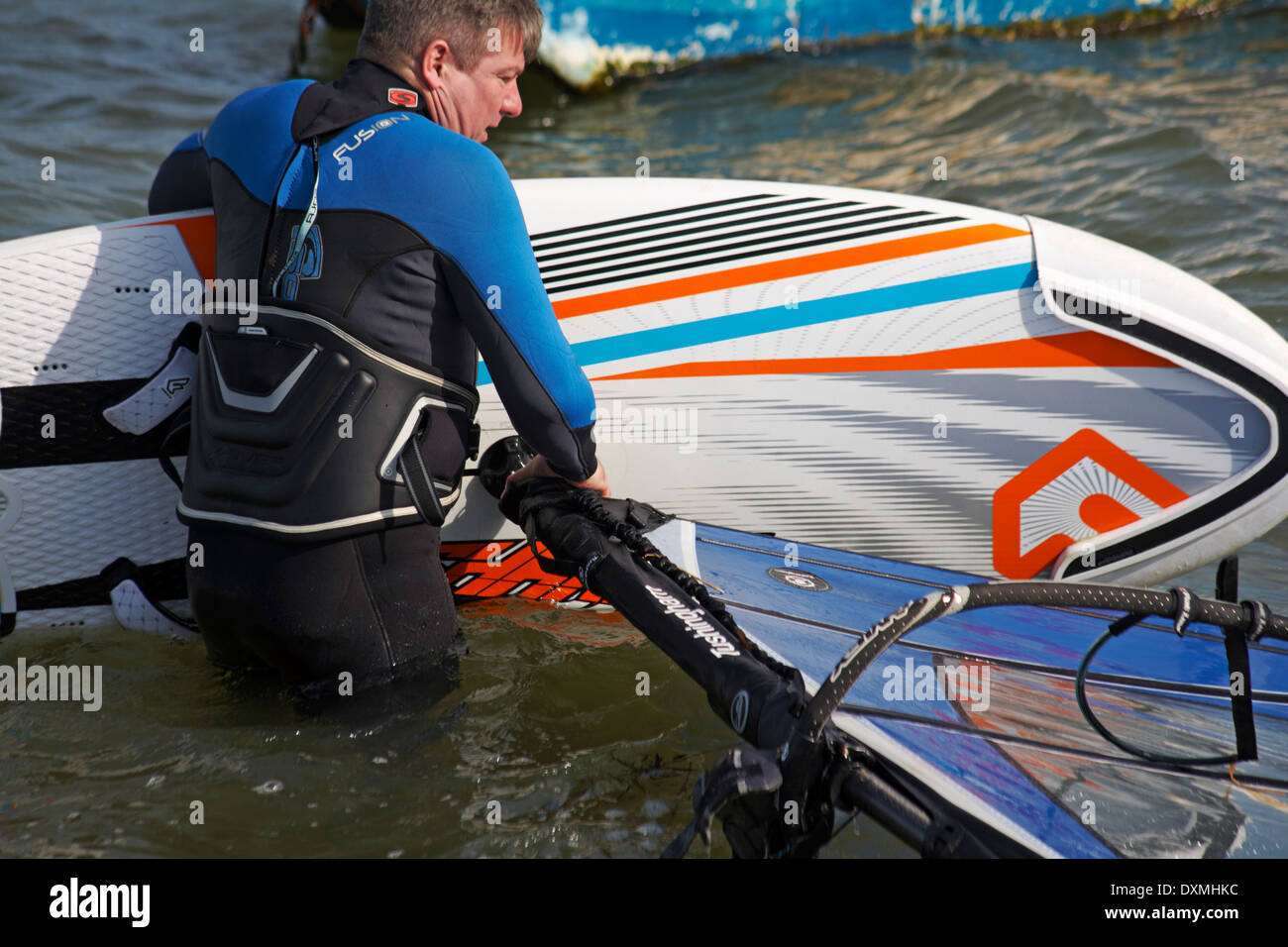 windsurfer getting set up ready to windsurf at Sandbanks, Poole in