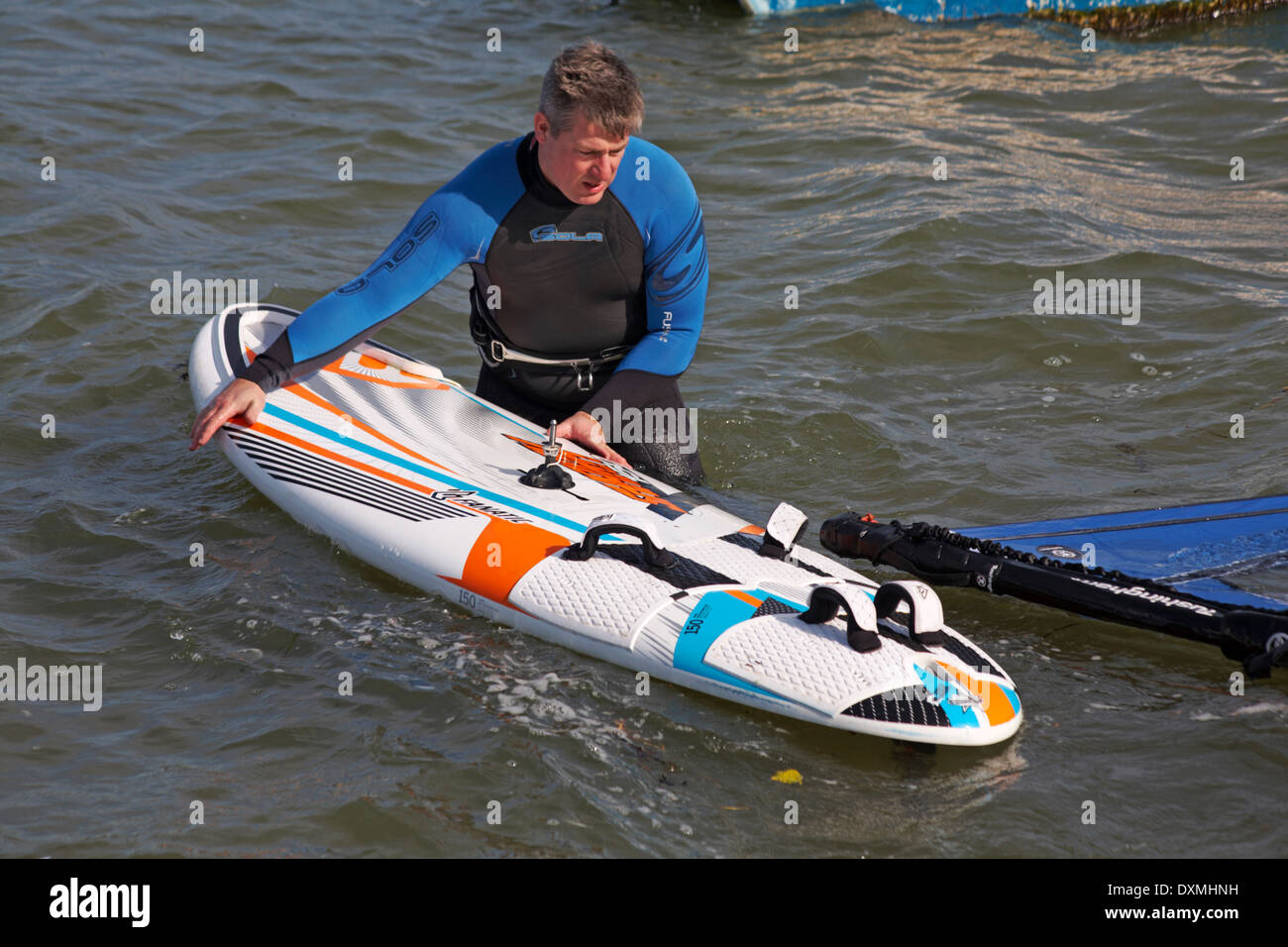 windsurfer getting set up ready to windsurf at Sandbanks, Poole in