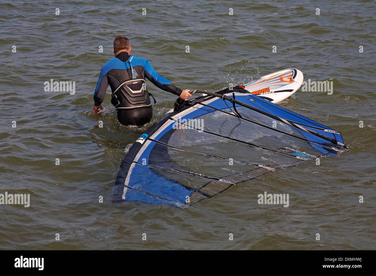 windsurfer getting set up ready to windsurf at Sandbanks, Poole in