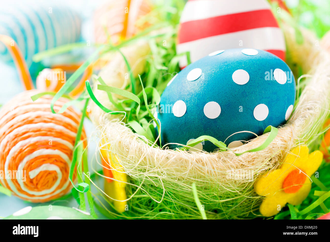 Dotted Eastern eggs in basket.Selective focus on the front blue egg. Stock Photo