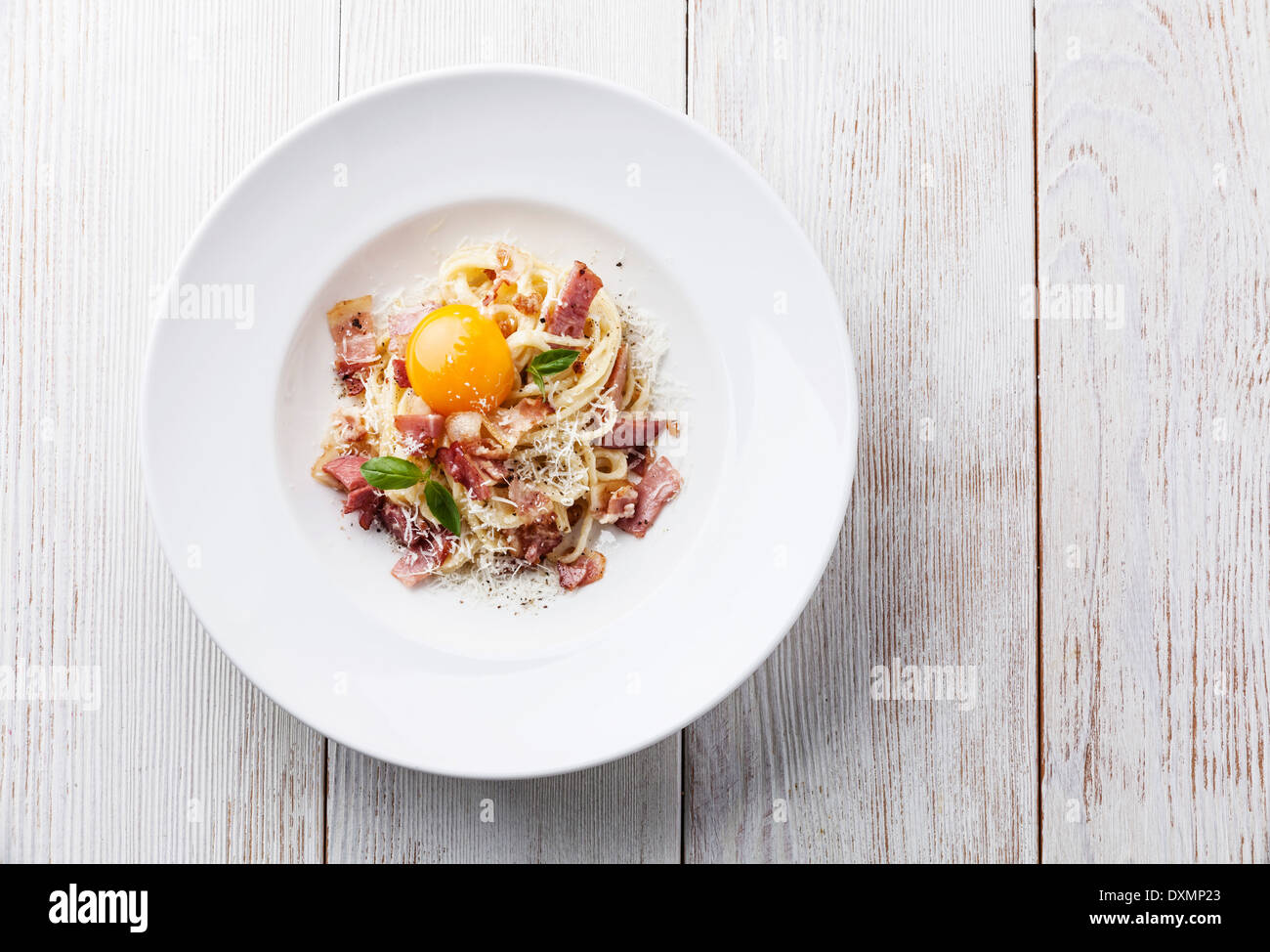 Spaghetti Carbonara on white plate with ham and yolk Stock Photo