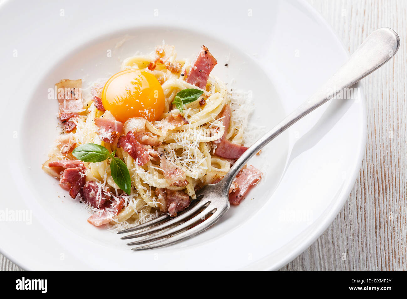 Spaghetti Carbonara on white plate with ham and yolk Stock Photo