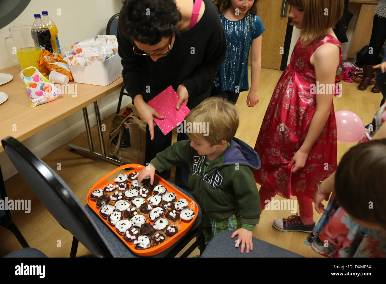 8 Year Old Girl's Birthday Party Boy Choosing Homemade Cupcake Dorset England Stock Photo