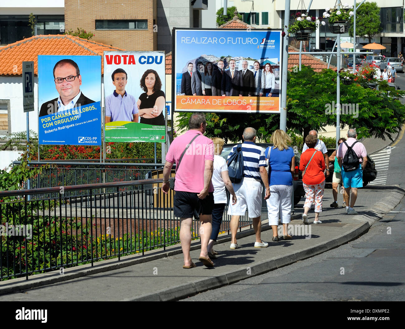 Madeira Portugal. Camara de lobos. Tourists walking past local election publicity signs Stock Photo