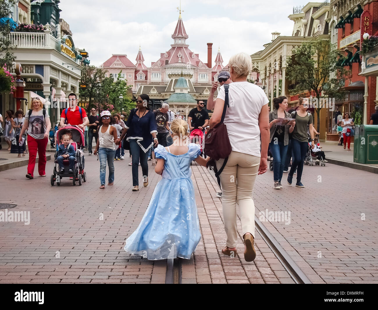 Little girl dressed in a Disney Princess costume and a female adult walk along main street at Disneyland Paris, france Stock Photo