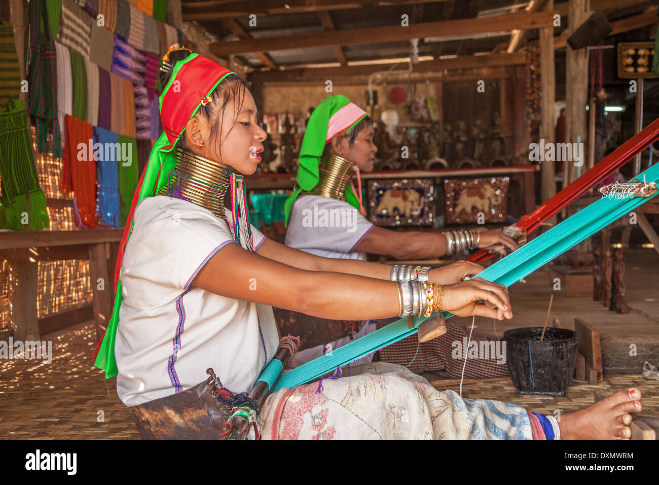 Padaung (Karen) tribe women weave on traditional device. Stock Photo