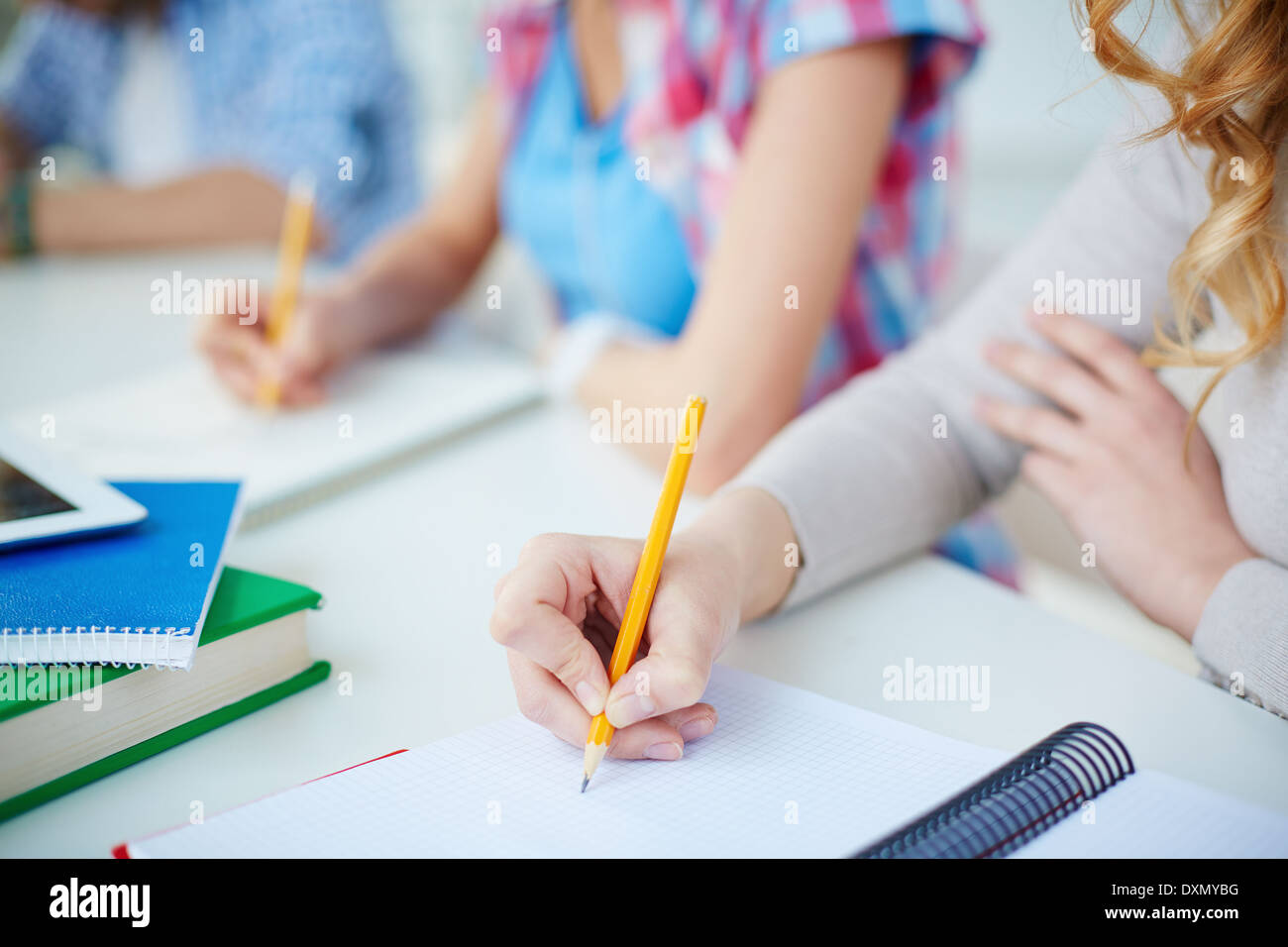 Several groupmates carrying out written task or writing lecture Stock Photo